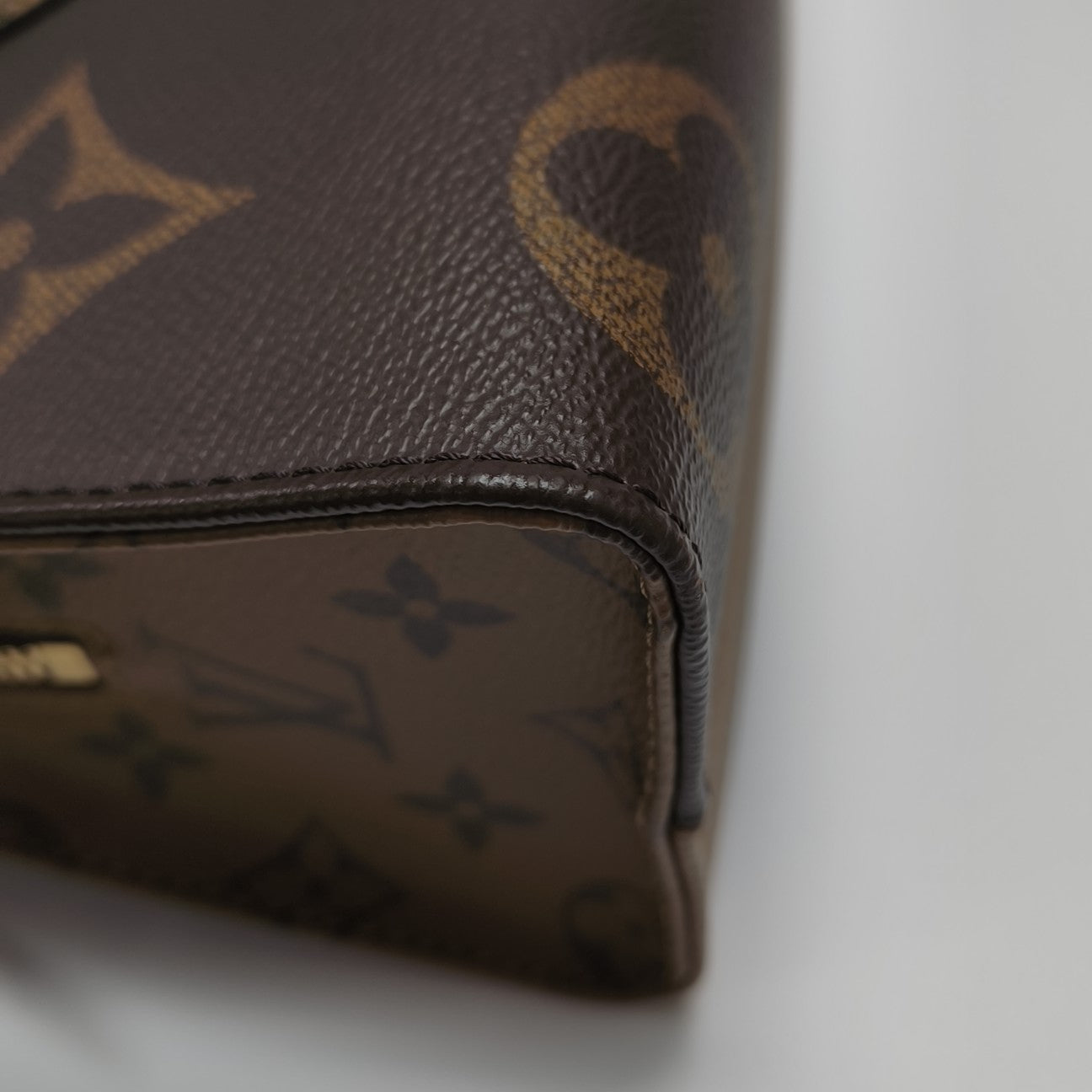 ONTHEGO EAST WEST Chain Monogram Coated Canvas Brown