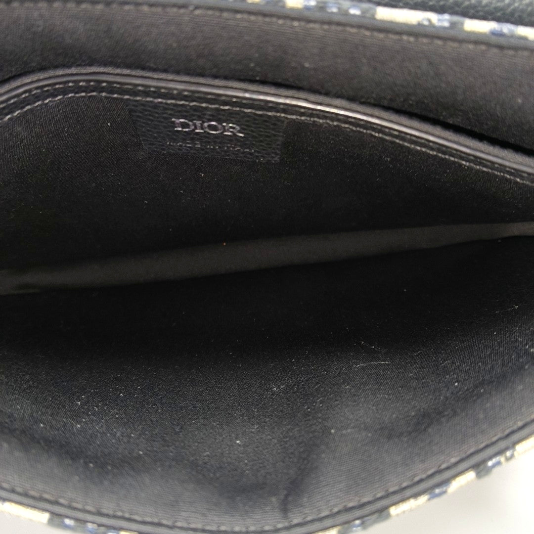 Authenticated pre-owned  Saddle Oblique Canvas Beige - Clutch at Looply